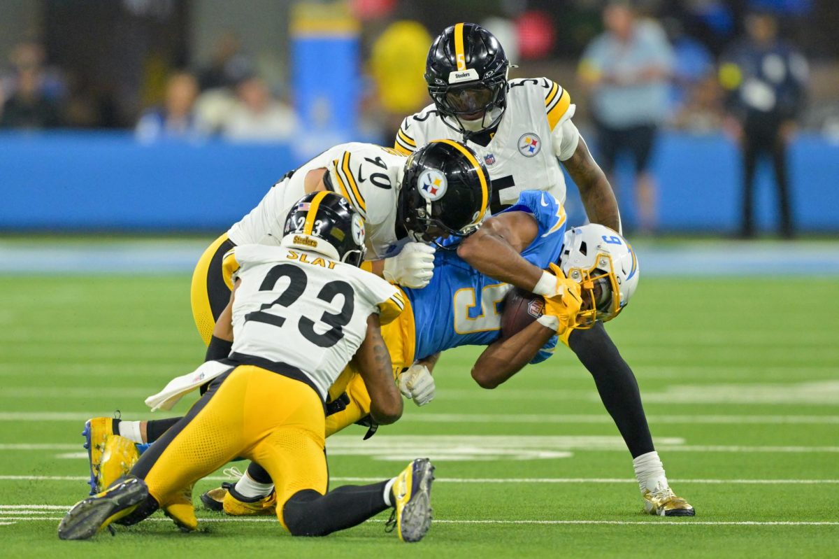Pittsburgh Steelers cornerback Darius Slay (23), linebacker T.J. Watt (90) and cornerback Jalen Ramsey (5) tackle Los Angeles Chargers wide receiver Tre' Harris (9) (Jayne Kamin-Oncea-reuters Images)
