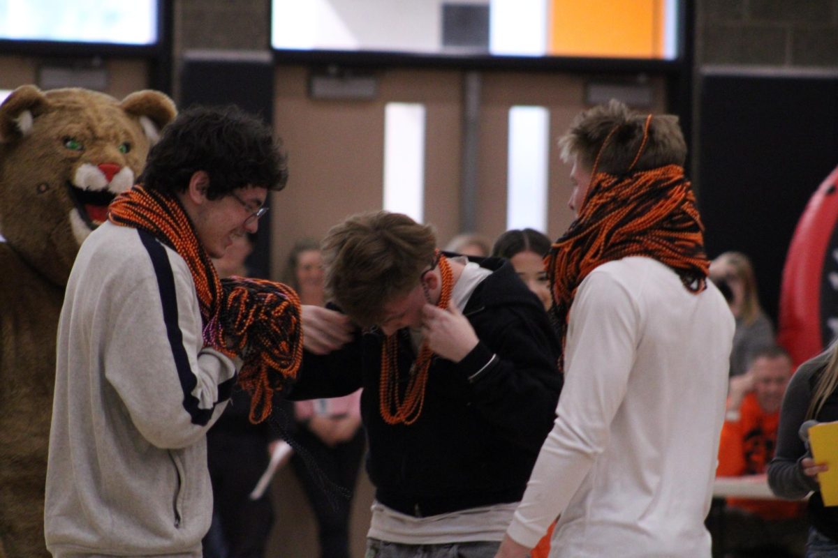 ___ (Middle) handing beads off to ____ (left) while ___ (Right) watches.