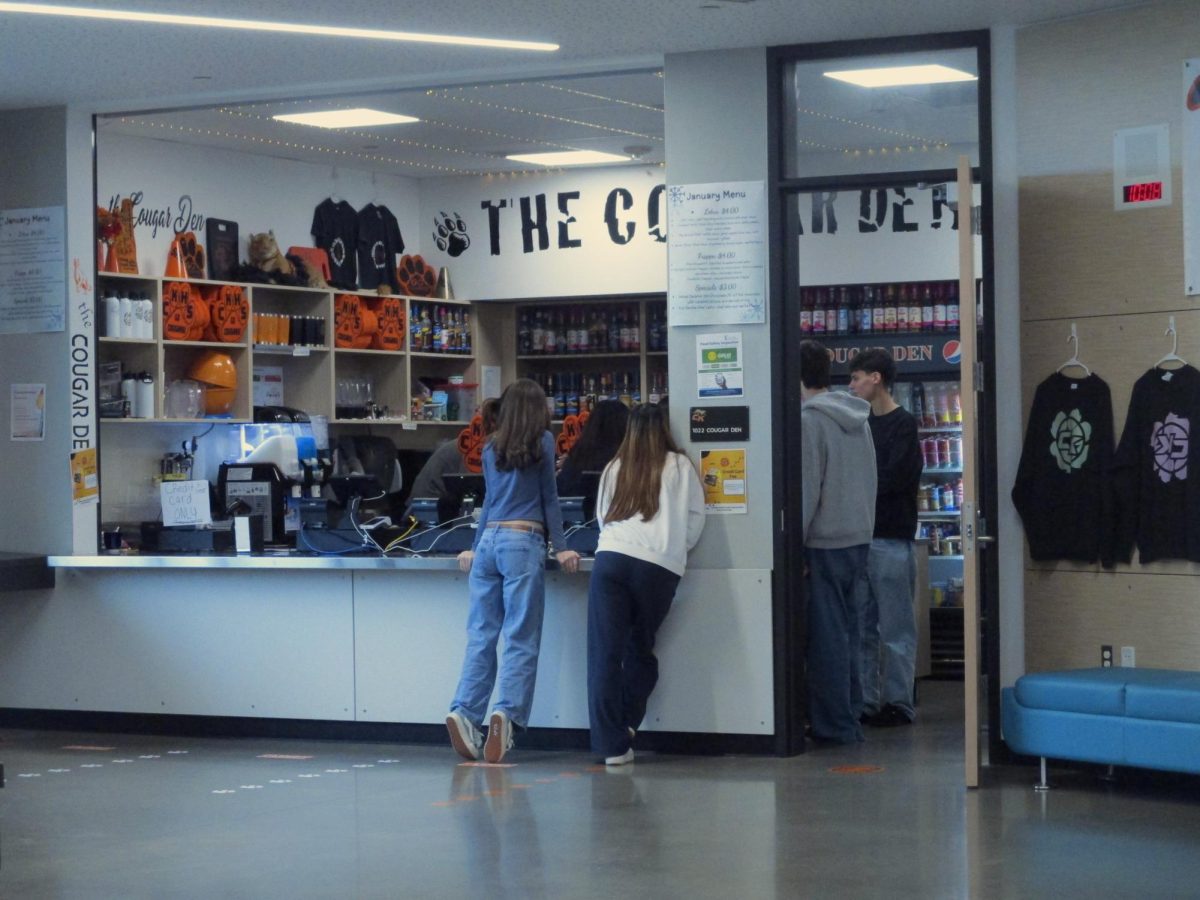 Two students peer into the Cougar Den as they prepare for lunch to start.