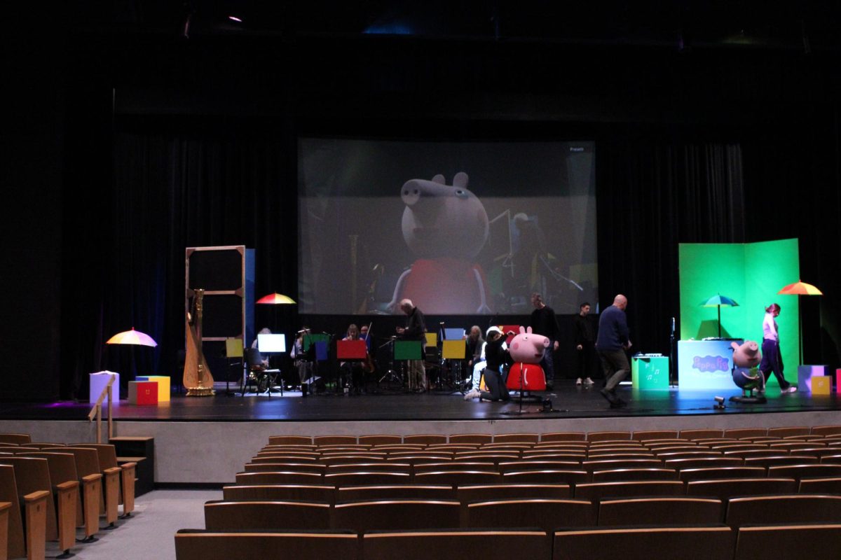 Cast members set up the stage for a technical rehearsal. 