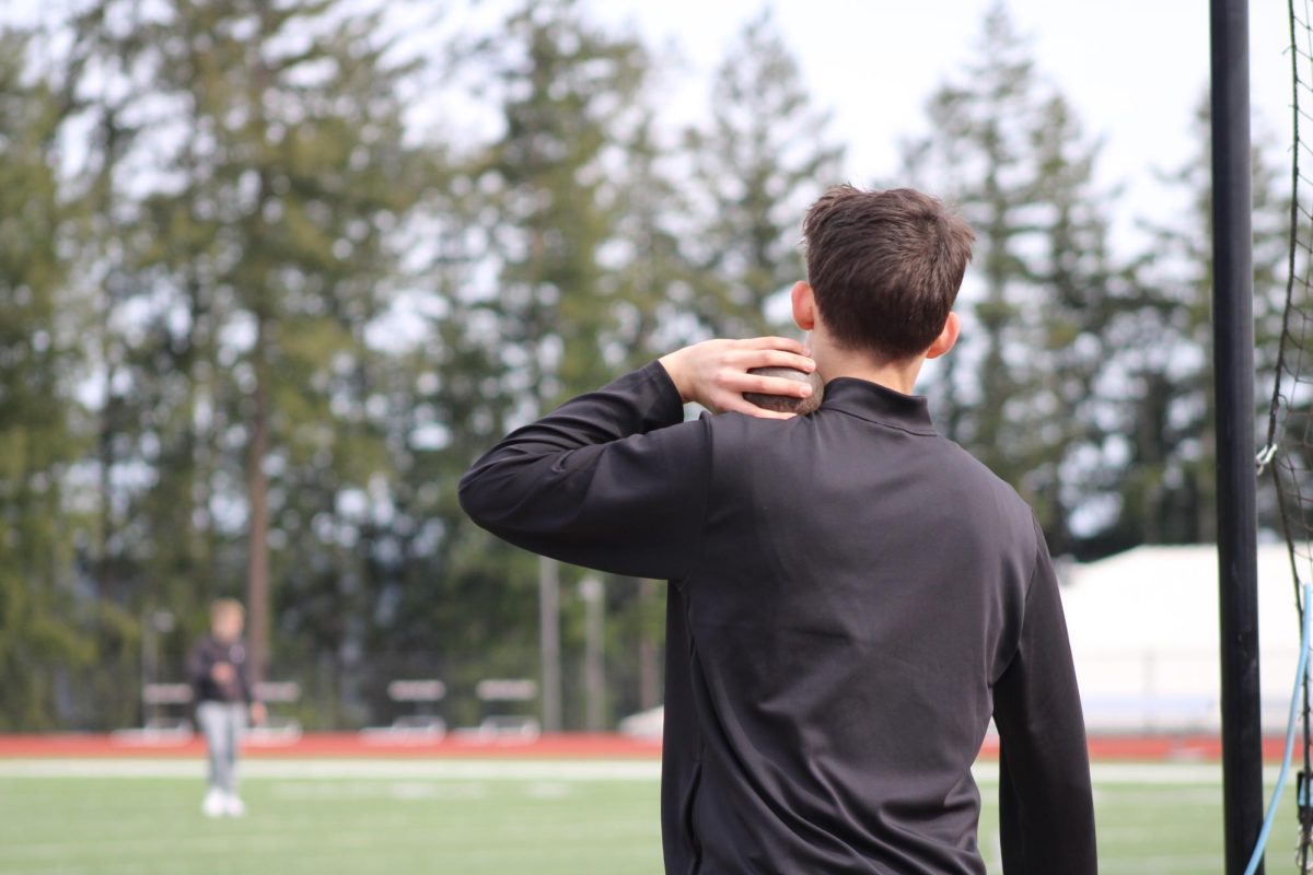 A student prepares to put a shot during track practice after school.