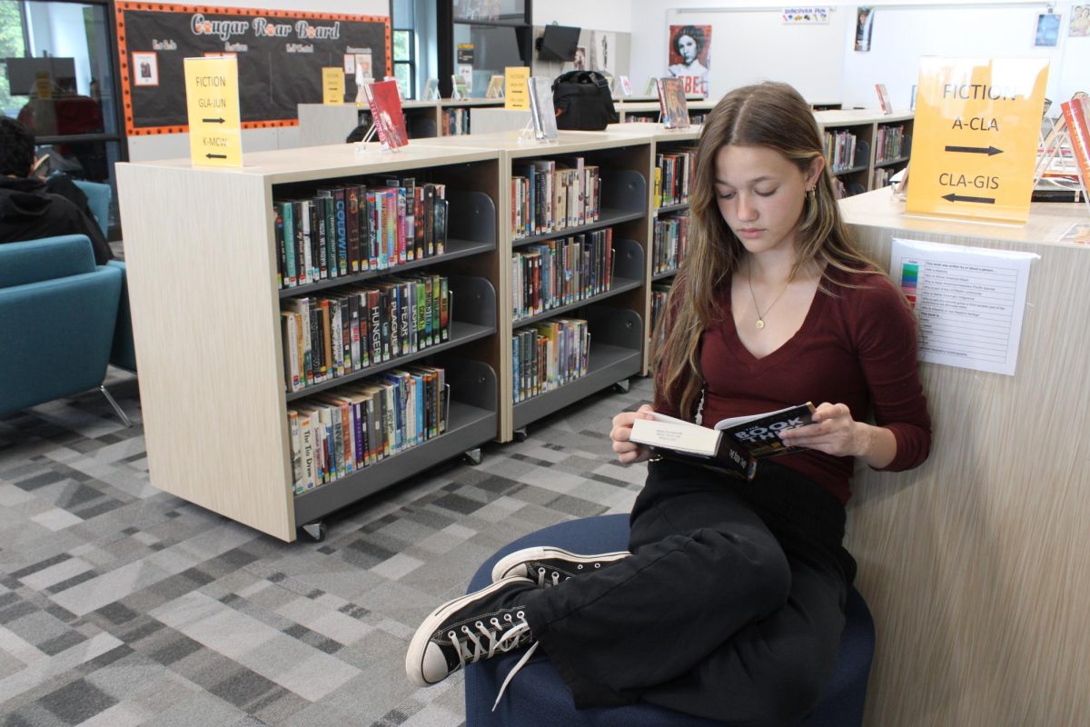 Student Chloe Miller reads a book in the Central Kitsap High School library.
