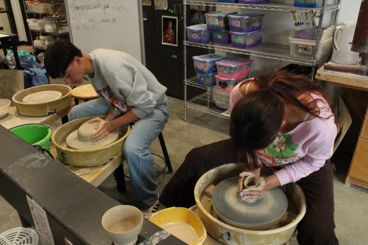 Joseph Ortega and Norah Gutierrez throw bowls on the potters' wheel.