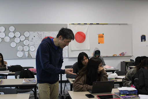 Japanese language teacher Moto Oishi helps a student in the third period English development class.